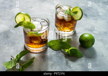 Rum und Cola. Cuba Libre trinken mit Kalk und Eis auf rustikalen konkrete Tabelle. Stockfoto
