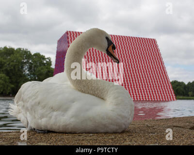 Bulgarischen Künstlers Christo stellt seine erste BRITISCHE Arbeiten im Freien, die Mastaba, eine 20 m hohe Installation auf See Serpentine Lake aus 7,506 Barrel. Die mastaba ist 30 Meter breit und 40 Meter lang. Die Fässer auf der Oberseite sichtbar und die beiden schrägen Wände sind rot und weiß gestrichen; während die Enden der Fässer auf die zwei senkrechten Wände sichtbar lackiert sind rot, blau und violett. Mit: Atmosphäre, Wo: London, England, Großbritannien Wann: 18 Jun 2018 Credit: Wheatley/WANN Stockfoto