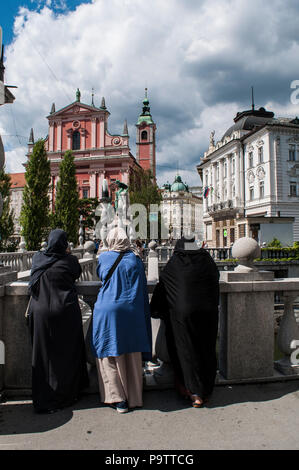 Ljubljana, Slowenien: muslimische Frauen in Prešeren-Platz mit Blick auf die Tromostovje, die drei Brücken, mit der Franziskaner Kirche der Mariä Verkündigung Stockfoto