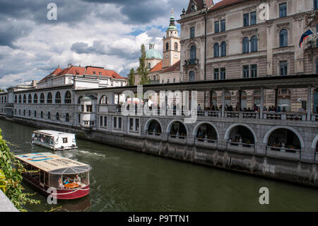 Slowenien, Europa: Er Skyline der Innenstadt von Ljubljana mit einem touristischen Boot Kreuzfahrt auf dem Fluss Ljubljanica, im Mittelalter bekannt als Ljubija Stockfoto