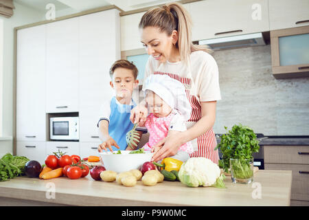 Mutter und Kinder kochen in der Küche
