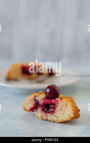 Scheiben frischen iced Biskuitteig mit Kirschen auf rustikalen hölzernen Hintergrund Stockfoto