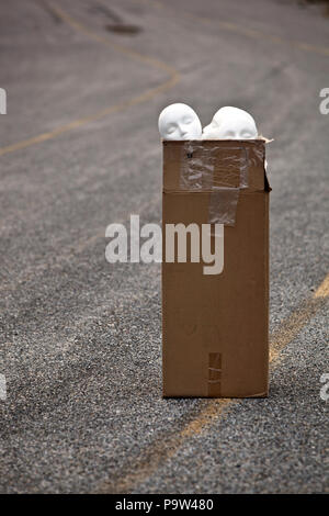 Styropor Mannequin heads sitzen in einem Karton in einem verlassenen Parkplatz Stockfoto
