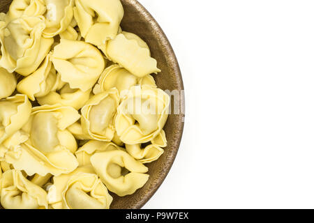 Raw tortellini Pasta in eine hölzerne Schüssel flatlay isoliert auf weißem Hintergrund traditionellen italienischen Knödel Stockfoto