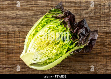 Die Hälfte der frischen grünen Salat rote kleine Juwel Vielzahl flatlay auf braunem Holz Stockfoto