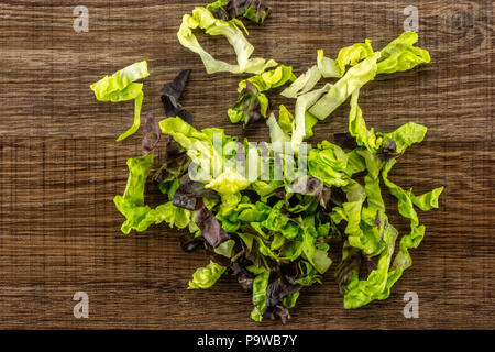 Frischer grüner Salat rote kleine Juwel Vielzahl gehackt flatlay auf braunem Holz Stockfoto