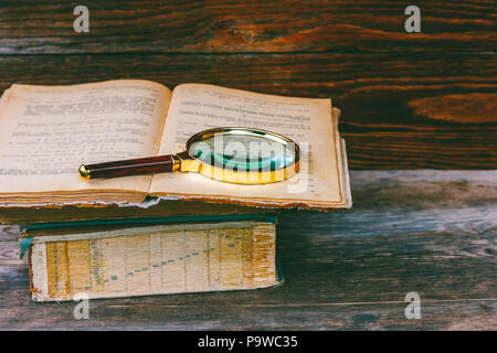 Lupe auf alten Buch öffnen closeup Stockfoto