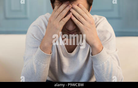 Keinen Ausweg. Unglücklich pessimistisch depressiven Mann bedeckte sein Gesicht und denken über seine Probleme, während in einer schwierigen Zeit im Leben Stockfoto