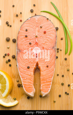 Rohe frische Stück Lachs auf einer hölzernen Hintergrund, Gewürzen, Pfeffer Stockfoto