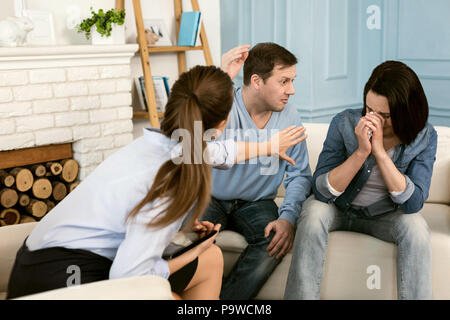 Machen Sie es nicht. Professionelle nette weibliche Therapeuten auf ihre Patienten und Stoppen einer Familie kämpfen, während ein paar Therapie Sitzung Stockfoto