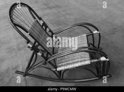 Schaukelstuhl aus natürlichem Holz und Rattan, Seitenansicht. schwarz-weiß Foto Stockfoto