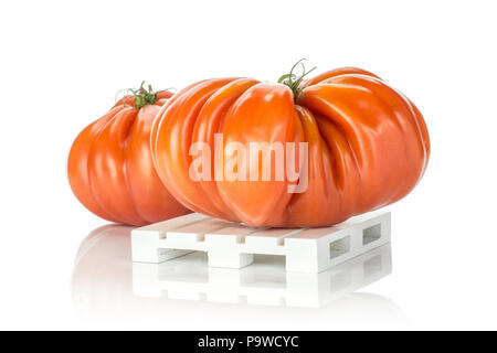 Zwei Rindfleisch Tomaten auf einer Holzpalette auf weißem Hintergrund große reife rote isoliert mit Rippen Stockfoto