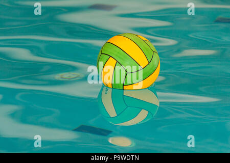 Gelbe und grüne Wasserball Ball mit Reflexion im Pool Stockfoto
