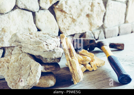 Stapel Flagstone und Bau Hammer gegen die Wand aus Stein Nahaufnahme. Konzept Neubau, Reparatur Stockfoto