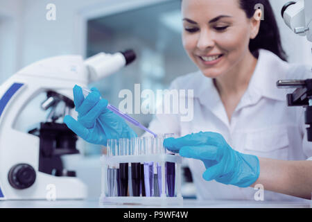 Die moderne Forschung. Happy positive weibliche Wissenschaftler lächelnd und nehmen Proben für ihre Forschung im Labor Stockfoto