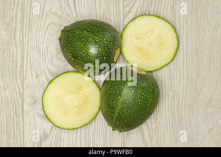 Flatlay Gruppe von zwei runden Zucchini und Hälften auf braunem Holz frische Sommer Squash Stockfoto