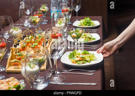 Die Bedienung ist über ein Salat auf den Tisch in einem Cafe Stockfoto