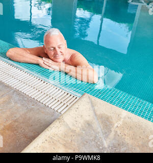 Erschöpft älterer Mann im Pool entspannt am Pool edge Stockfoto