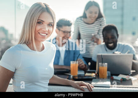 Positiv begeistert Blonde posing vor der Kamera Stockfoto