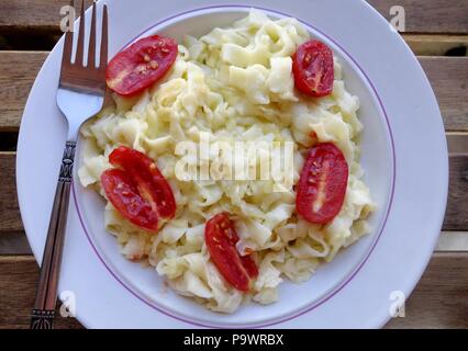 Griechische traditionelle Pasta Hilopites Kontes mit geriebenem Käse und Tomaten Stockfoto