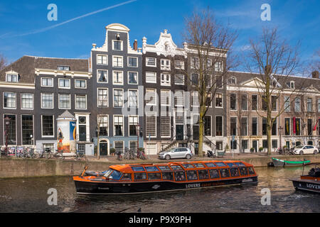 Schiff an einer Gracht in Amsterdam, Niederlande, Europa mit traditionellen Grachtenhäuser hinter Stockfoto