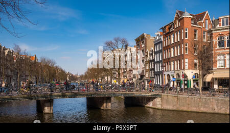 Viele Fahrräder auf einer Brücke mit Blick auf eine Gracht in Amsterdam, Niederlande, Europa Stockfoto