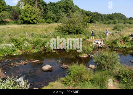 East Dart River bei Postbridge, Dartmoor, Devon, England, UK Besucher am Flussufer. Stockfoto