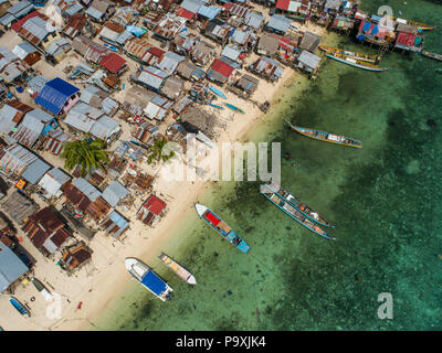 Eine Drohne Foto auf einem sehr schlechten Bajau Sea Gypsy Village, und Strand, Boote, und flachen tropischen Wasser, auf Mabul Island, Sabah, Malaysia. Stockfoto