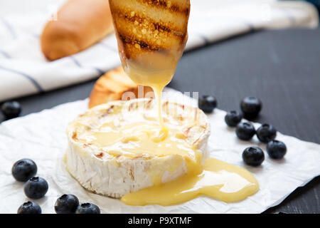 Gegrilltem Camembert, Seitenansicht. Close-up. Schwarzen Hintergrund. Stockfoto