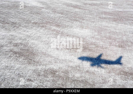 Von zivilen Flugzeugen fällt ein Schatten auf einem schneebedeckten Feld unter Final Approach-Pfad der Jet Stockfoto