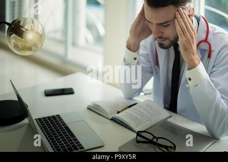 Ärzte sind die ernsten Gesichter und gestresst von der Arbeit. Der Arzt ist ein Gefühl der Kopfschmerzen bei der Arbeit und das Gefühl, in der Behandlung des Patienten betont. Stockfoto