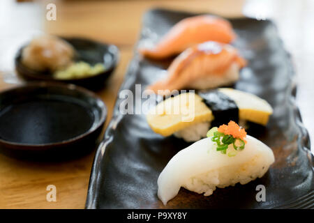 Verschiedene Sorten von sushi Platte. Roher Fisch Sushi. Japanisches Essen. Lachs brennen, Lachs, ika und tamago Sushi im japanischen Restaurant. Stockfoto