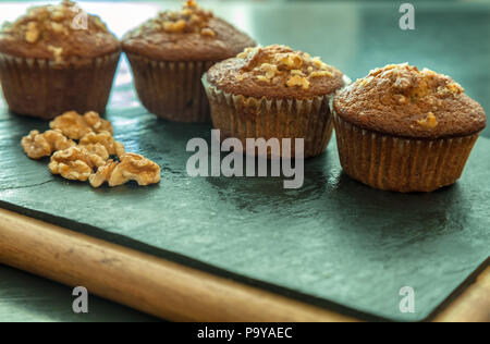 Anzeige der Banane nuss Muffins mit Walnüssen auf einem Schneidebrett. Stockfoto