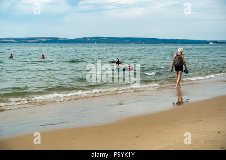 Die Menschen genießen einen Montag Morgen am Meer im Juli am Strand von Bournemouth, Dorset, Großbritannien Stockfoto