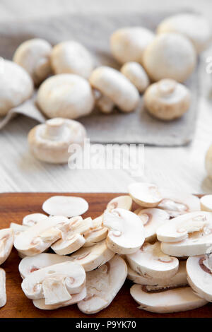 Gehackte Pilze auf Holz Schneidebrett, Nahaufnahme. Weiß Holz- Hintergrund. Stockfoto