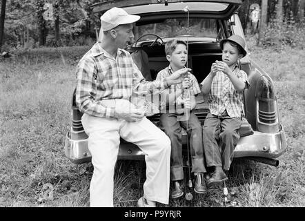 1960 Mann Vater und zwei jungen Söhne ZWILLINGE AM HINTEREN STOSSFÄNGER AUTO die FANGGERÄTE-a2310LAN001 HARS LEHRE NOSTALGIE GANG BRUDER OLD FASHION AUTO 1 JUGENDLICHE FAHRZEUG TEAMARBEIT/FERIENHÄUSER SÖHNE IDENTISCHE DOPPEL FAMILIEN FREUDE LIFESTYLE PARENTING BRÜDER ZEIGT LÄNDLICHE GESUNDHEIT VORBEREITUNG VOLLER LÄNGE PERSONEN INSPIRATION MATCH AUTOMOBIL FÜRSORGLICHE MÄNNER GESCHWISTER TRANSPORT VÄTER B&W FREIHEIT PASSENDE GLEICHZEITIG AUS GLÜCK ABENTEUER UND AUTOS GETAWAY VATIS WISSEN STOSSFÄNGER AUF BEHÖRDE URLAUB GESCHWISTER ANWEISEN VERBINDUNG AUTOMOBILE ESCAPE FAHRZEUGE - Duplizieren Stockfoto