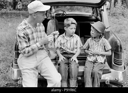 1960 Mann Vater und zwei jungen Söhne ZWILLINGE AM HINTEREN STOSSFÄNGER AUTO die FANGGERÄTE-a2316 LAN001 HARS LEHRE NOSTALGIE GANG BRUDER OLD FASHION AUTO 1 JUGENDLICHE FAHRZEUG TEAMARBEIT/FERIENHÄUSER SÖHNE IDENTISCHE DOPPEL FAMILIEN FREUDE LIFESTYLE PARENTING BRÜDER ZEIGT LÄNDLICHE GESUNDHEIT VORBEREITUNG mit halber Länge PERSONEN INSPIRATION MATCH AUTOMOBIL FÜRSORGLICHE MÄNNER GESCHWISTER TRANSPORT VÄTER B&W FREIHEIT PASSENDE GLEICHZEITIG AUS GLÜCK ABENTEUER UND AUTOS GETAWAY VATIS WISSEN STOSSFÄNGER AUF BEHÖRDE URLAUB GESCHWISTER ANWEISEN VERBINDUNG AUTOMOBILE ESCAPE FAHRZEUGE - Duplizieren Stockfoto