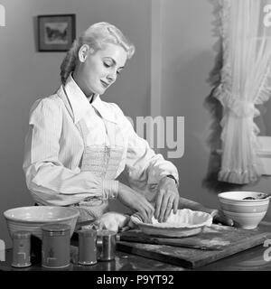 1940er Jahre 1950er Jahre blonde Frau ZUBEREITUNG TEIG EINE KRUSTE EINE TORTE - h 1691 HAR 001 HARS GERNE FREUDE LIFESTYLE FRAUEN STOLZ HOME LEBEN VORBEREITUNG KOPIEREN RAUM MIT HALBER LÄNGE DAMEN PERSONEN INSPIRATION VERTRAUEN AUSDRÜCKE B&W TEIG FRÖHLICHE FREIZEIT KRUSTE WISSEN STOLZ BEHÖRDE LÄCHELT FRÖHLICH STILVOLLE KREATIVITÄT PRÄZISION ENTSPANNUNG junger Erwachsener FRAU SCHWARZ UND WEISS KAUKASISCHEN ETHNIE HAR 001 ALTMODISCH ZU BACKEN Stockfoto