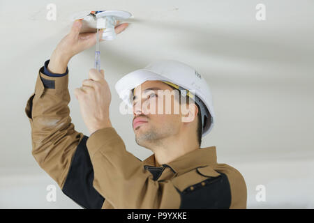 Elektriker installieren Deckenleuchten Stockfoto