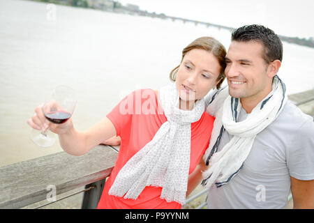 Paar durch Fluss, Frau Glas Rotwein Stockfoto