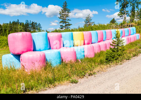 Bunte Silageballen in der Natur gestapelt. Stockfoto