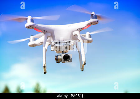 Weiß Quadrocopter fliegen hoch in der Luft, die Fotos und die Aufnahme Aufnahmen von oben. Flying drone mit vier Motoren und Propeller, Kamera Stockfoto