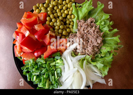Abstrakte, verschwommen gedreht. Frisch zubereitete Gemüse Salate auf Platte auf rustikalen Hintergrund. Thunfisch mit grünen Salat, Erbsen, Paprika oder Paprika, Zwiebel Stockfoto