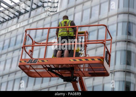 Mann in einem Cherry Picker oder mobile Hubsteiger MEWP. city hall London. Stockfoto