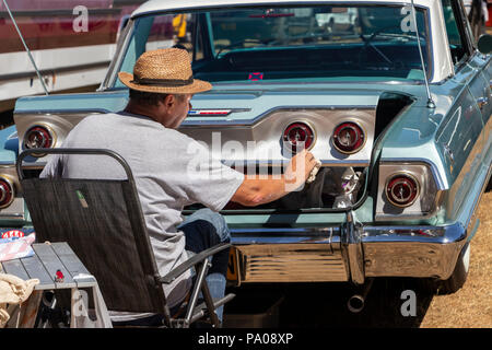 Ein Mann, der seinen alten 1960er Chevrolet Impala auf der American Classics Car Show im Tatton Park UK poliert Stockfoto