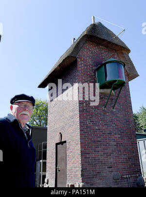 Oland, Deutschland. 05 Juni, 2018. Leuchtturmwärter Juergen Nommensen steht am Leuchtturm von der Hallig Oland. Es ist ziemlich Unremarkably an der nordwestlichen Seite der nur Wohnung Damm der Hallig entfernt. Rote Ziegelsteine, strohgedeckten Dach mit Schilf und mit einer Firsthöhe von nur 7, 45 Meter ist es kaum von anderen Gebäuden an der Wohnung Damm unterscheidet. Credit: Carsten Rehder/dpa/Alamy leben Nachrichten Stockfoto