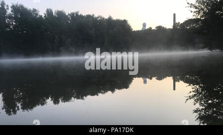 Berlin, Deutschland. 20. Juli 2018. Bodennebel über den Teufelsee See während der frühen Morgen. Im Hintergrund der Turm der ehemaligen Hörstation der Alliierten auf dem Teufelsberg gesehen werden. Credit: Paul Zinken/dpa/ZB/dpa/Alamy leben Nachrichten Stockfoto