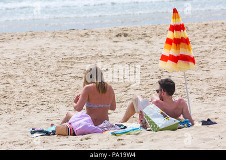 Bournemouth, Dorset, Großbritannien. Juli 2018 20. UK Wetter: heiß und feucht, mit trüben Sonnenschein in Bournemouth, als Sonnenanbeter Kopf ans Meer in Bournemouth Strand das schöne Wetter zu genießen. Paar sonnenbaden. Credit: Carolyn Jenkins/Alamy leben Nachrichten Stockfoto