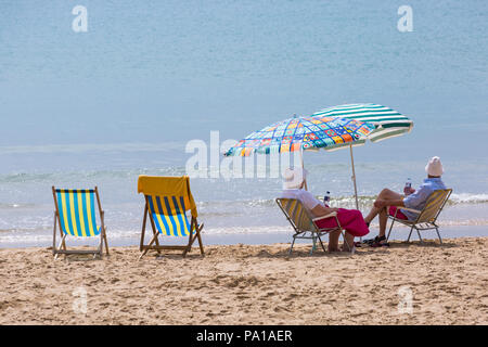 Bournemouth, Dorset, Großbritannien. Juli 2018 20. UK Wetter: heiß und feucht, mit trüben Sonnenschein in Bournemouth, als Sonnenanbeter Kopf ans Meer in Bournemouth Strand das schöne Wetter zu genießen. Paar Entspannen am Meer. Credit: Carolyn Jenkins/Alamy leben Nachrichten Stockfoto