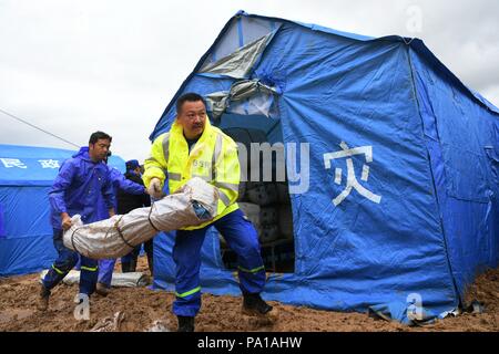 Dongxiang, Gansu Provinz Chinas. 20. Juli 2018. Retter vermitteln Katastrophenhilfe Materialien bei Flut - schlagen Chenhe Dorf Dongxiang autonomen Grafschaft in Linxia Hui Autonomen Präfektur im Nordwesten der chinesischen Provinz Gansu, 20. Juli 2018. Über 1,08 Millionen Menschen in der Provinz Gansu wurden durch Regen ausgelöste Hochwasser betroffen, mit 12 Toten, vier Personen vermisst und 27.000 Menschen evakuiert. Credit: Chen Bin/Xinhua/Alamy leben Nachrichten Stockfoto